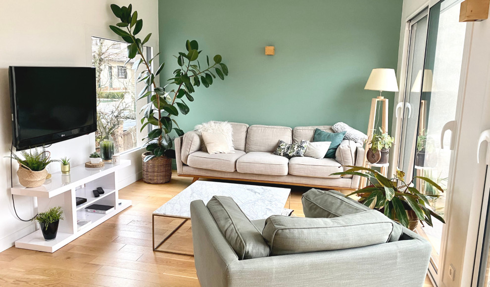 Стильный дизайн: открытая гостиная комната среднего размера в стиле неоклассика (современная классика) с зелеными стенами, светлым паркетным полом, отдельно стоящим телевизором, бежевым полом и обоями на стенах без камина - последний тренд