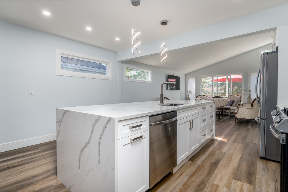 Kitchen - transitional kitchen idea in Edmonton with shaker cabinets, white cabinets, quartzite countertops, gray backsplash, cement tile backsplash, stainless steel appliances, an island and white countertops