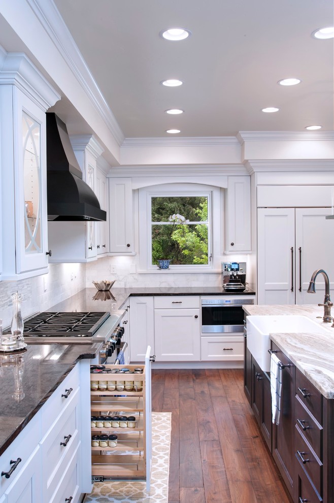 Mid-sized transitional u-shaped dark wood floor and brown floor eat-in kitchen photo in Denver with a farmhouse sink, shaker cabinets, white cabinets, marble countertops, gray backsplash, marble backsplash, stainless steel appliances and an island