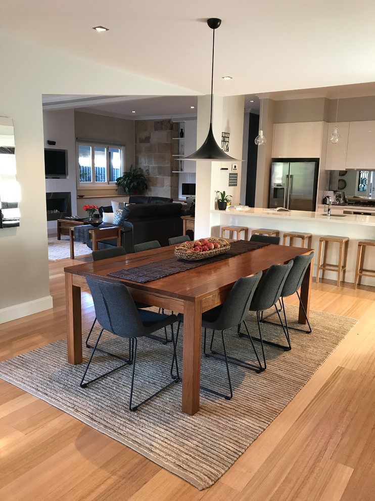 Photo of a large contemporary open plan dining in Sydney with grey walls and light hardwood floors.