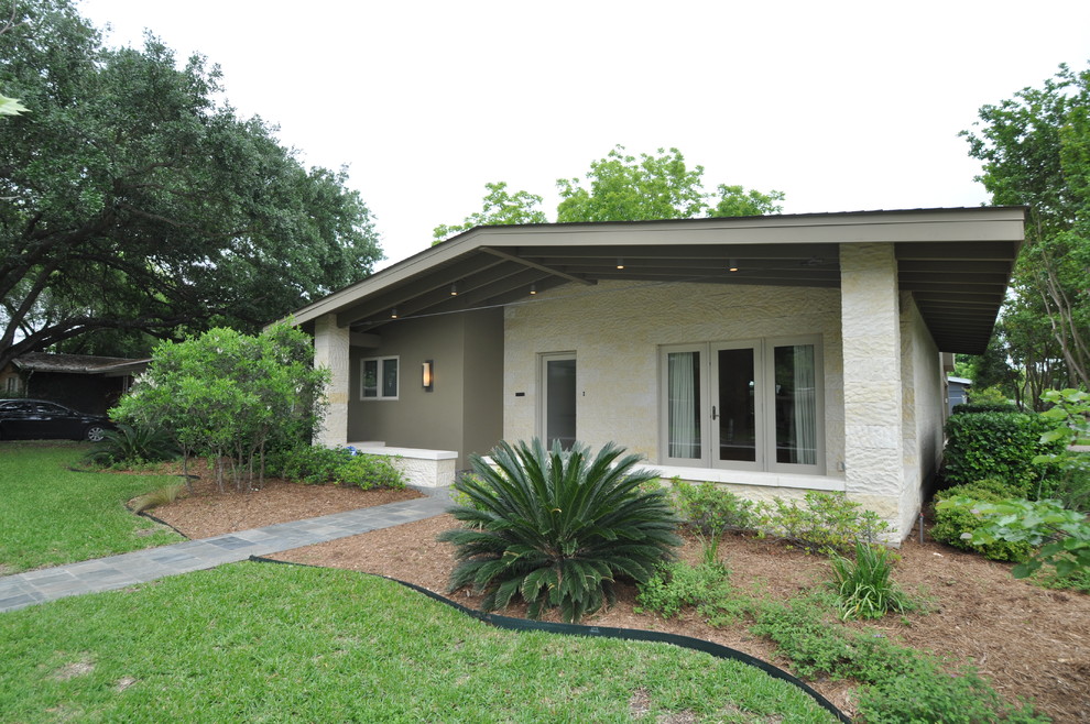 Photo of a midcentury one-storey exterior in Austin with stone veneer.