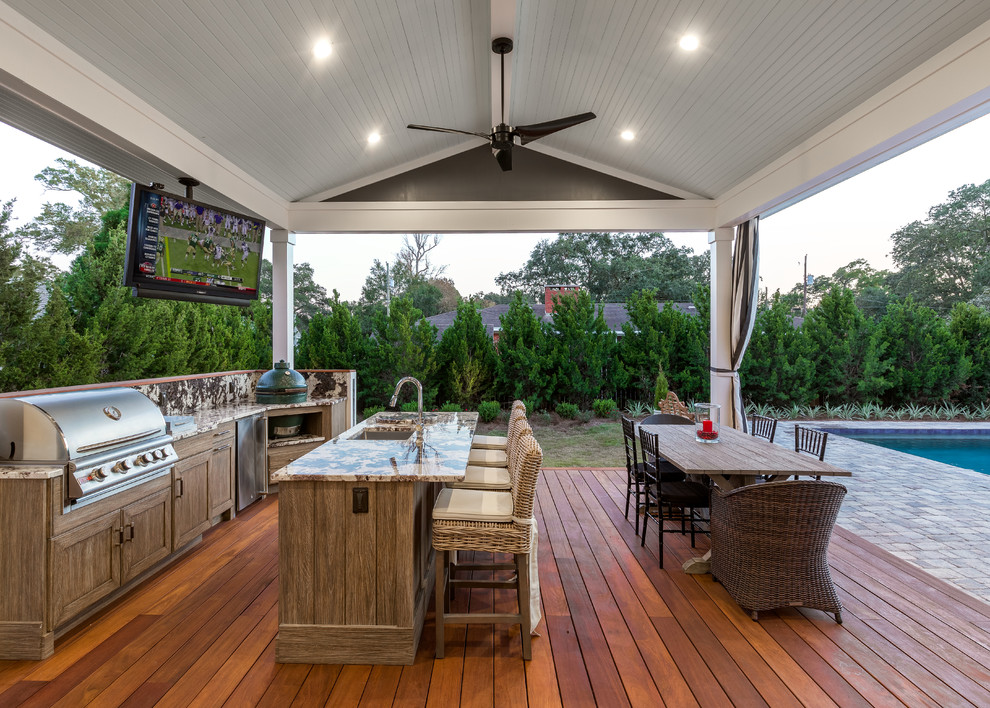 Large traditional backyard deck in Other with a roof extension.