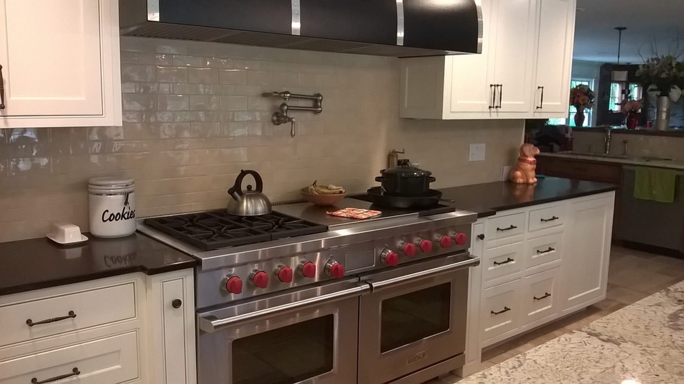 Kitchen - transitional kitchen idea in Minneapolis with recessed-panel cabinets, white cabinets, granite countertops and beige backsplash