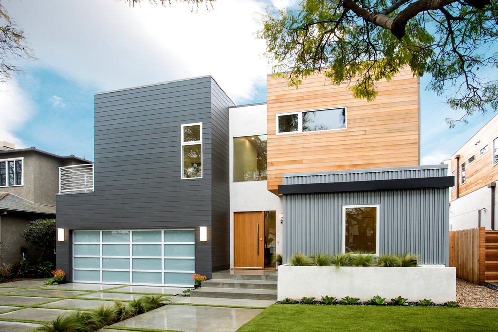 Design ideas for a contemporary two-storey exterior in Los Angeles with mixed siding and a flat roof.