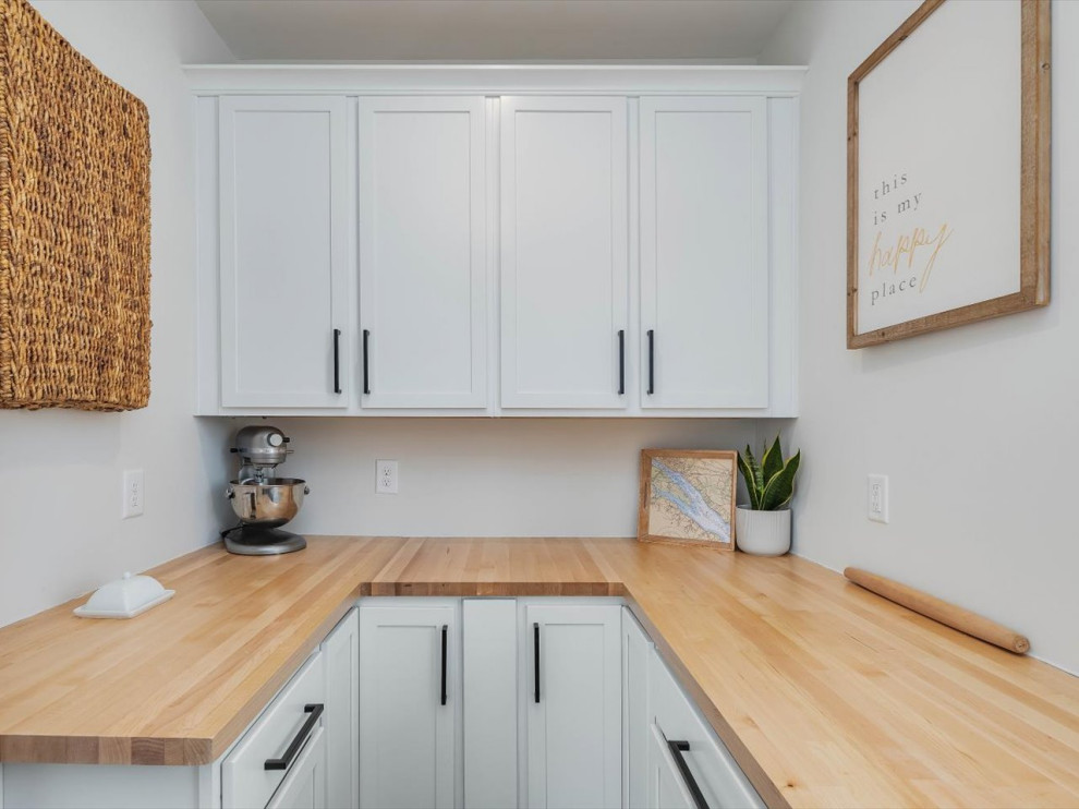 Small beach style u-shaped kitchen pantry in DC Metro with recessed-panel cabinets, white cabinets, wood worktops, stainless steel appliances, no island and brown worktops.