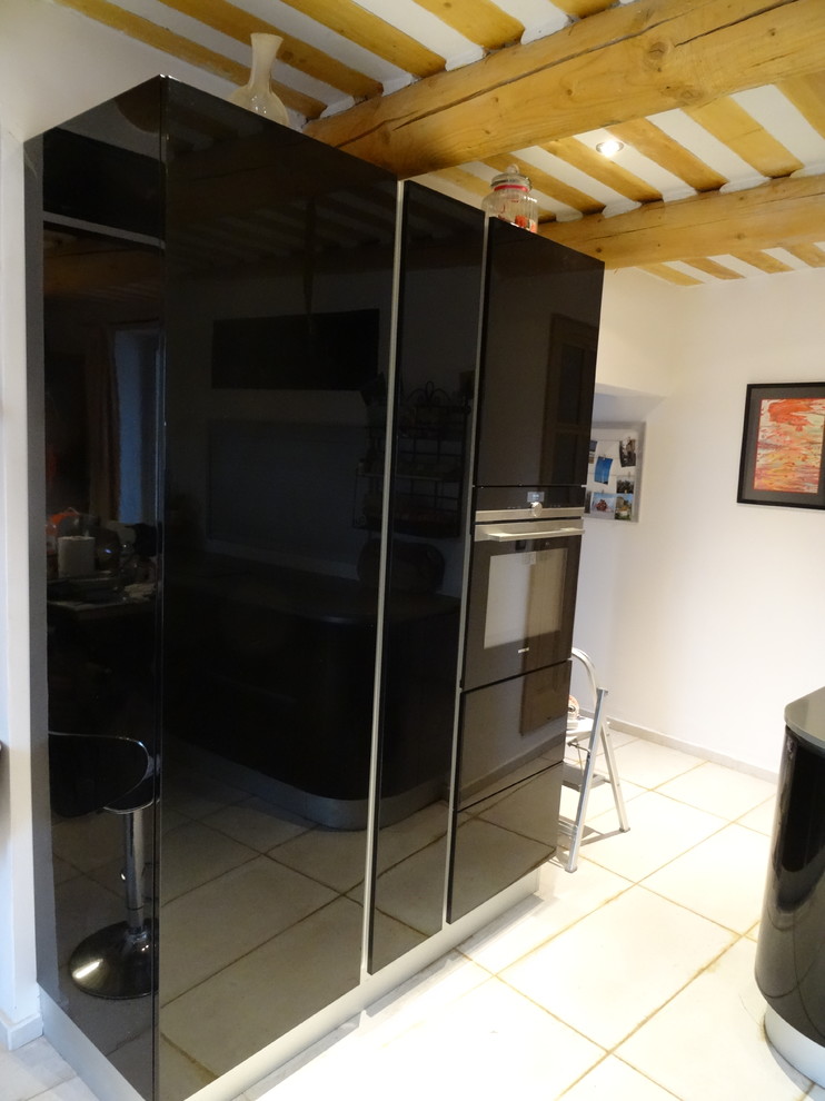 Idée de décoration pour cuisine ouverte in L With un évier intégré, un placard à porte affleurante, des portes de placard noires, un plan de travail en quartz, un électroménager noir and aucun îlot.