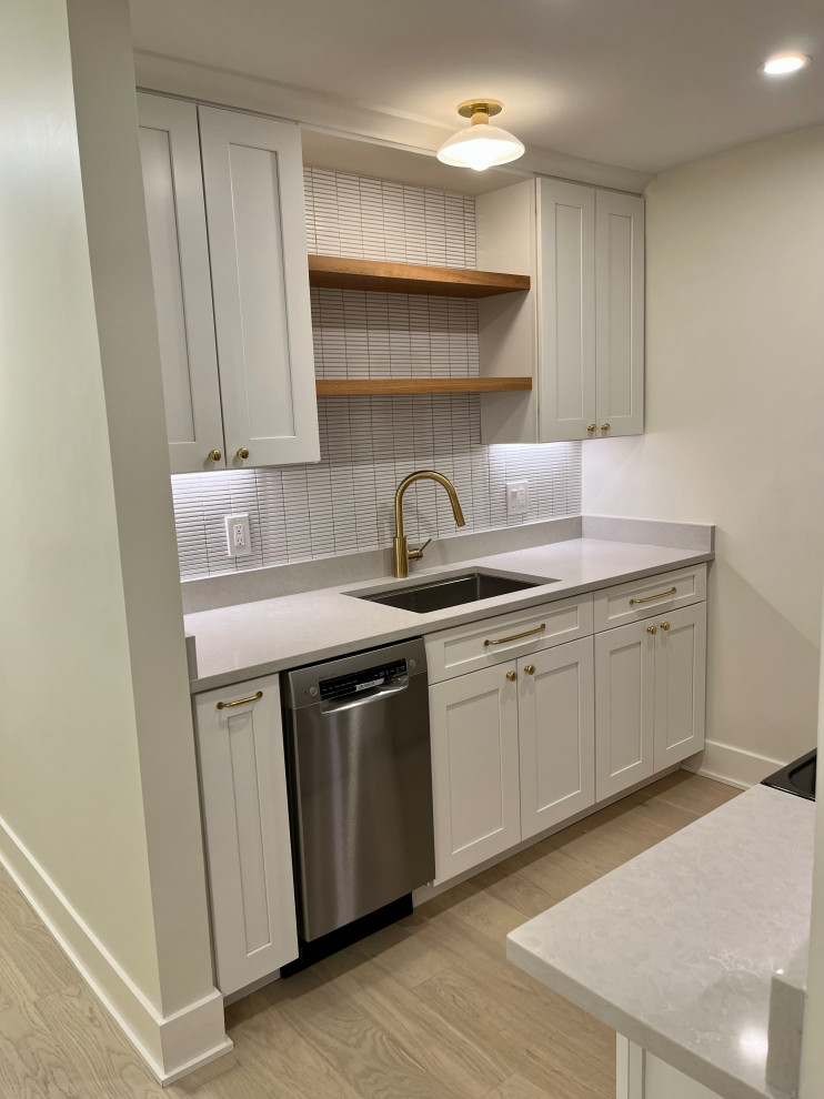 Inspiration for a small modern galley separate kitchen in DC Metro with an undermount sink, recessed-panel cabinets, white cabinets, laminate benchtops, ceramic splashback, stainless steel appliances, light hardwood floors, no island, multi-coloured floor, grey benchtop and coffered.