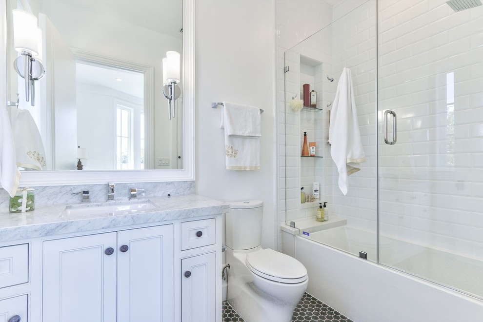 Inspiration for a traditional 3/4 bathroom in Los Angeles with beaded inset cabinets, white cabinets, an alcove tub, a shower/bathtub combo, white tile, white walls, an undermount sink, grey floor and a hinged shower door.