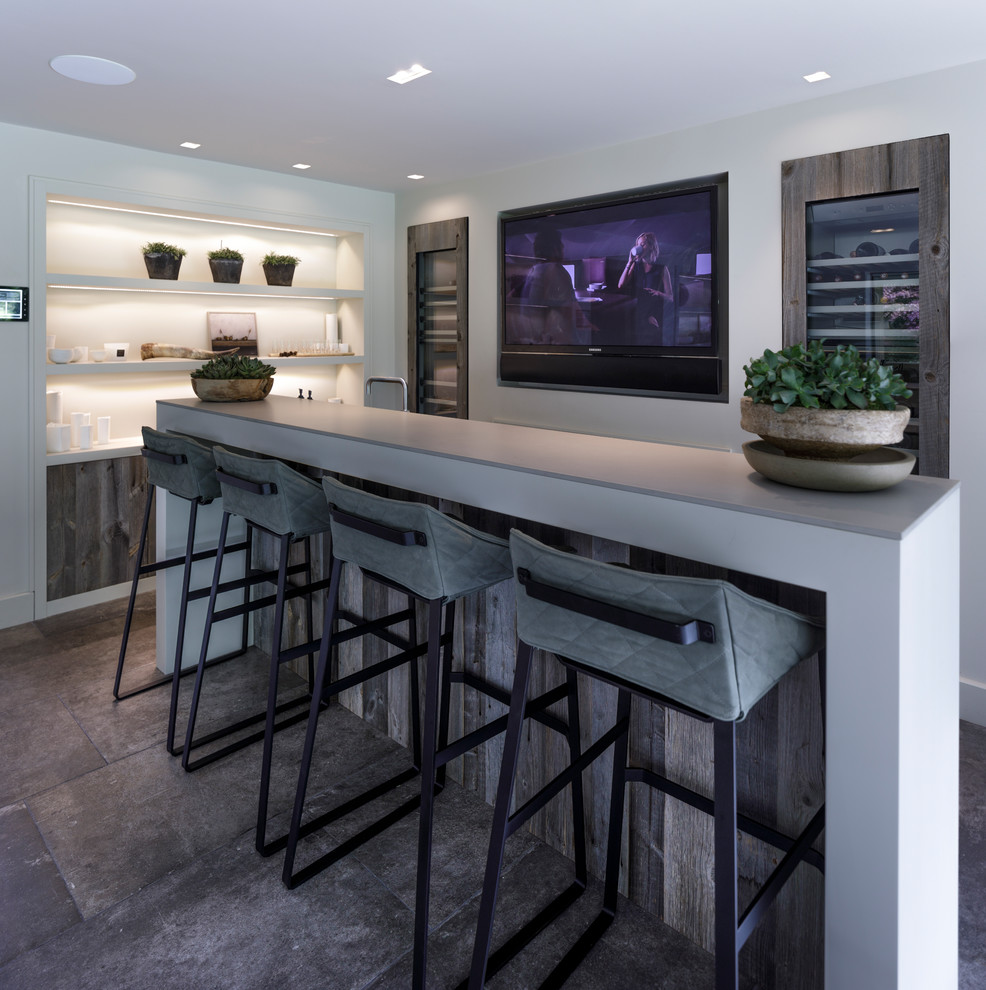Design ideas for a mid-sized contemporary galley wet bar in Cheshire with a drop-in sink, flat-panel cabinets, medium wood cabinets, concrete benchtops, white splashback, ceramic floors and grey floor.