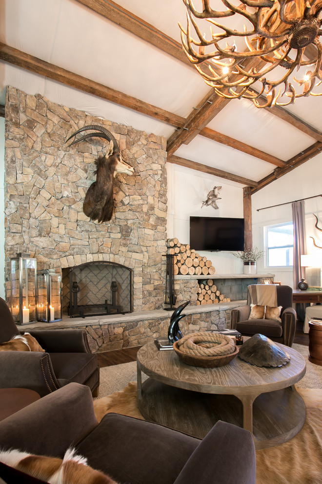Mid-sized country open concept family room in Charleston with white walls, medium hardwood floors, a standard fireplace, a stone fireplace surround, a wall-mounted tv and brown floor.