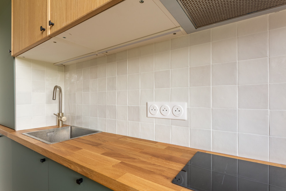Foto di una cucina moderna di medie dimensioni con lavello a vasca singola, ante in legno chiaro, top in legno, paraspruzzi bianco, paraspruzzi con piastrelle di cemento, parquet chiaro, pavimento marrone e top marrone