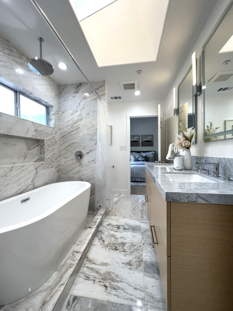 На фото: маленькая ванная комната в современном стиле с плоскими фасадами, светлыми деревянными фасадами, полновстраиваемой ванной, душем в нише, унитазом-моноблоком, серой плиткой, мраморной плиткой, белыми стенами, мраморным полом, душевой кабиной, врезной раковиной, мраморной столешницей, серым полом, шторкой для ванной, белой столешницей, тумбой под две раковины и подвесной тумбой для на участке и в саду с