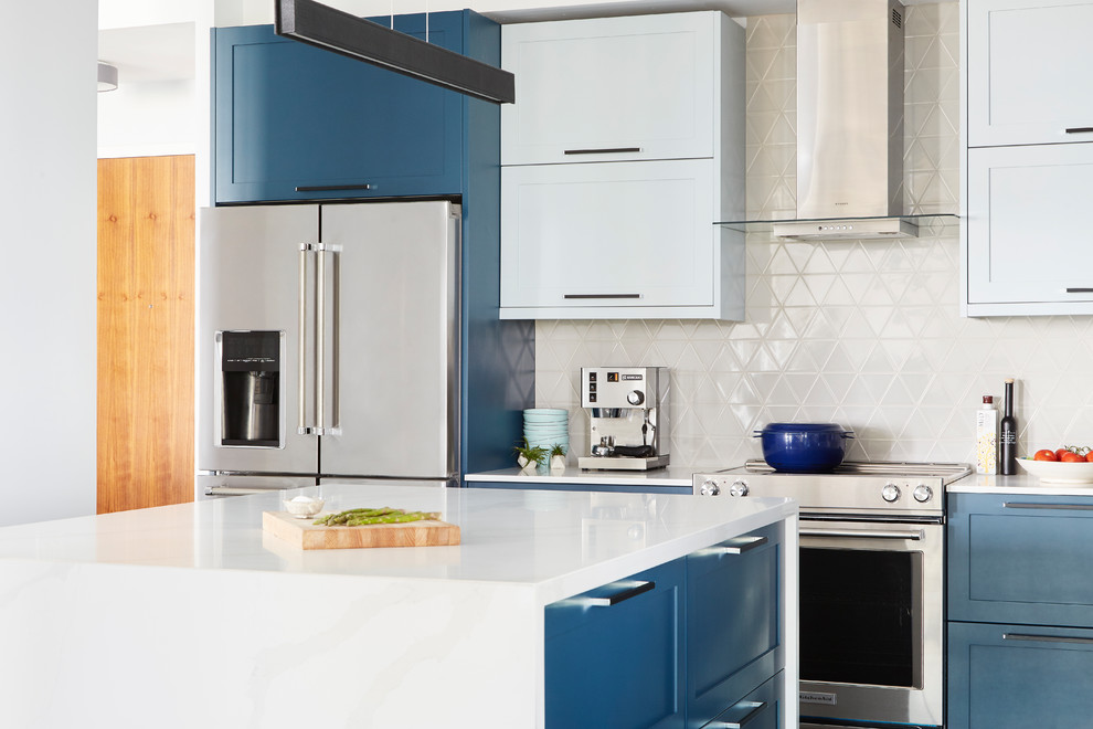 Mid-sized modern l-shaped eat-in kitchen in Toronto with a single-bowl sink, shaker cabinets, blue cabinets, quartz benchtops, beige splashback, ceramic splashback, stainless steel appliances, dark hardwood floors, with island, brown floor and white benchtop.