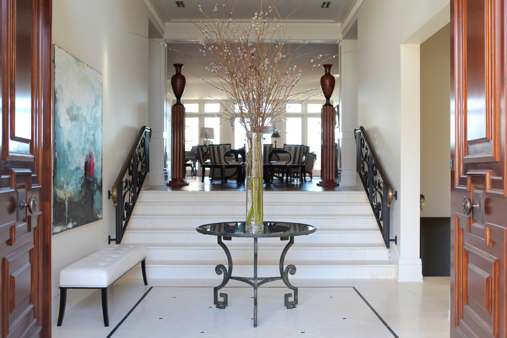 Foyer - large transitional marble floor foyer idea in Calgary with white walls and a dark wood front door