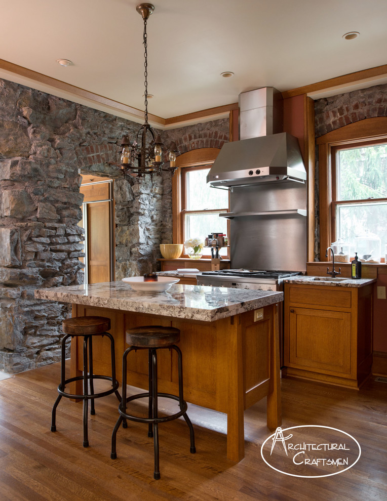 Photo of a country kitchen in Kansas City with a farmhouse sink, shaker cabinets, medium wood cabinets, granite benchtops and panelled appliances.