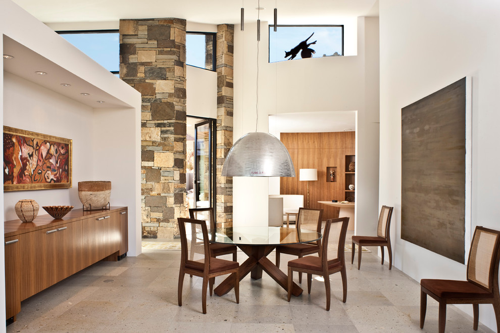 This is an example of an expansive modern open plan dining in Phoenix with white walls and grey floor.