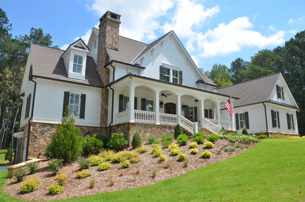 Large country two-storey white house exterior in Atlanta with vinyl siding, a gable roof and a shingle roof.