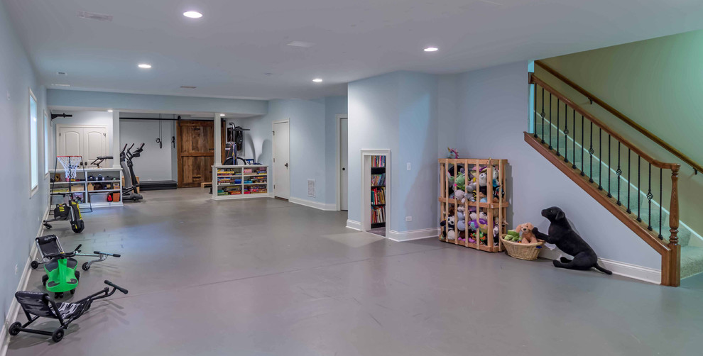 This is an example of a large arts and crafts fully buried basement in Chicago with blue walls, concrete floors, grey floor, a game room, no fireplace, exposed beam and wallpaper.