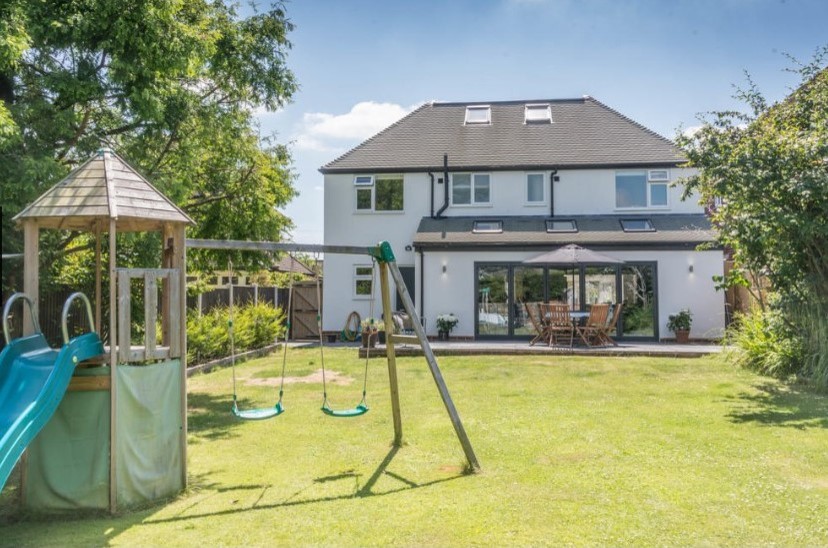 Photo of a large and white contemporary render detached house in Other with three floors, a pitched roof and a tiled roof.