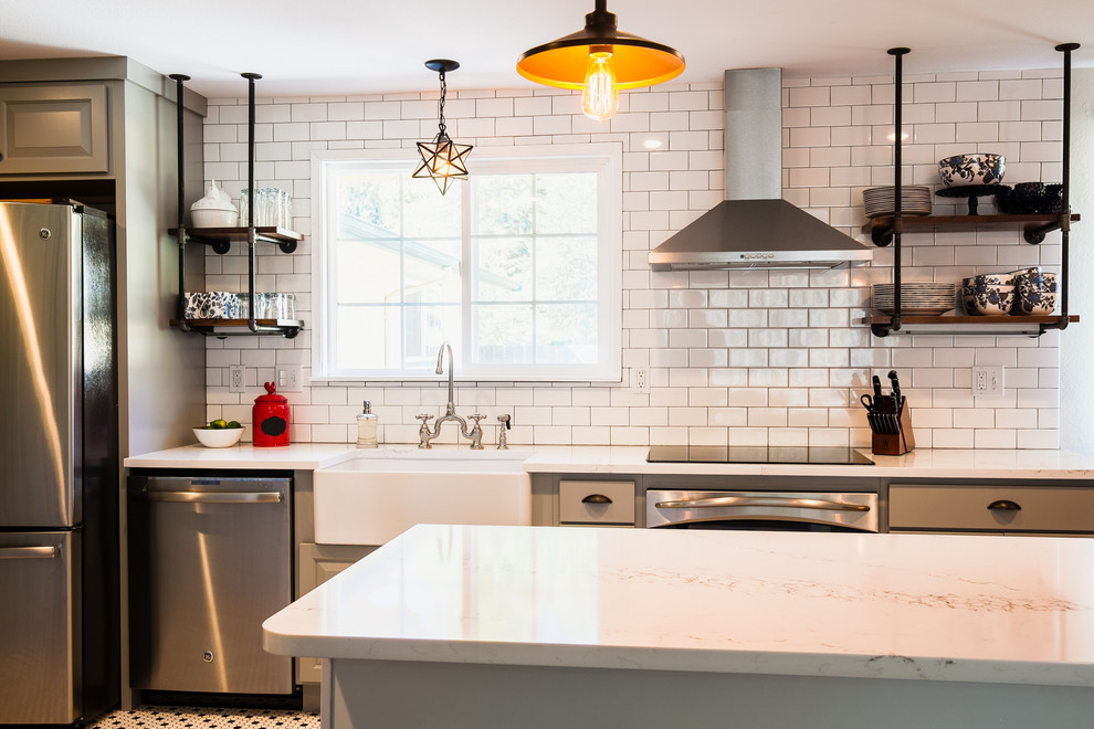 Inspiration for a mid-sized country galley open plan kitchen in Seattle with a farmhouse sink, shaker cabinets, grey cabinets, quartz benchtops, white splashback, subway tile splashback, stainless steel appliances, ceramic floors, with island and multi-coloured floor.