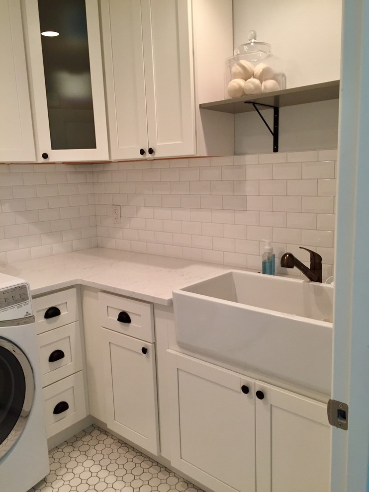 Small country galley dedicated laundry room in Seattle with a farmhouse sink, shaker cabinets, white cabinets, quartz benchtops, grey walls, porcelain floors, a side-by-side washer and dryer and white floor.