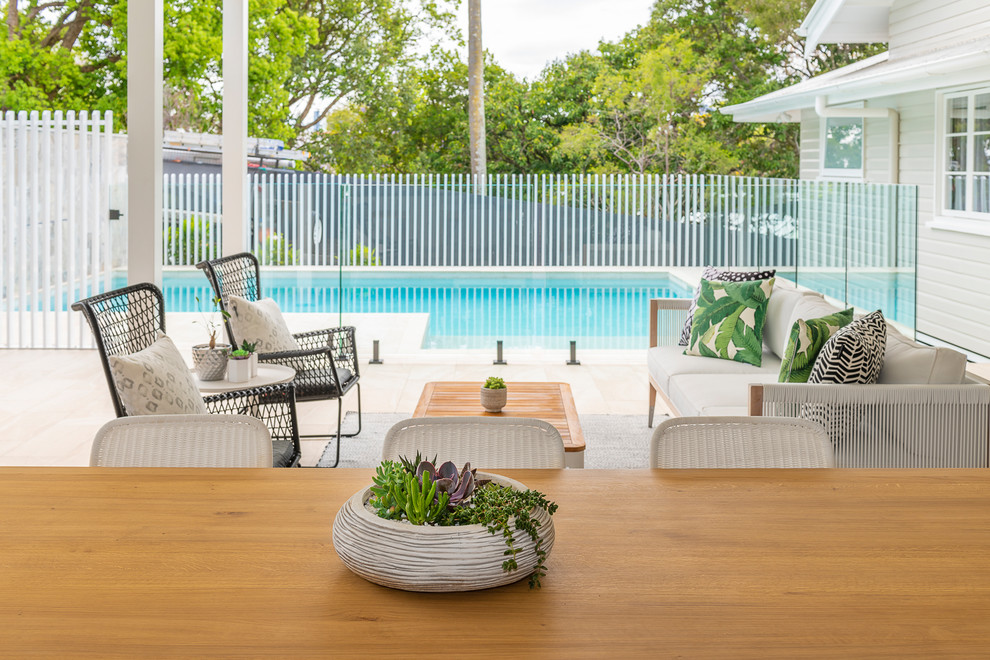 Large contemporary backyard patio in Brisbane with an outdoor kitchen, tile and a roof extension.