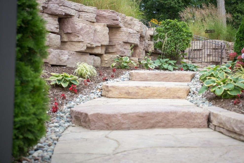 This is an example of a mid-sized transitional full sun backyard stone landscaping in Chicago.