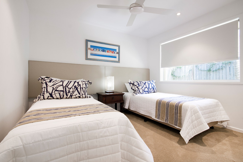 Photo of a mid-sized beach style guest bedroom in Sunshine Coast with white walls, carpet and beige floor.