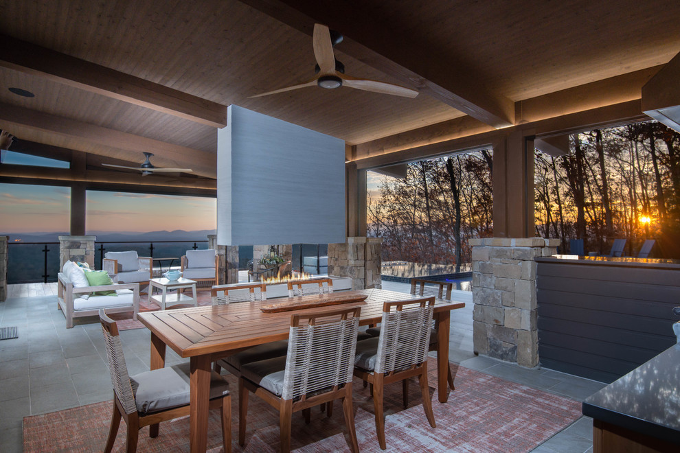 Large contemporary backyard patio in Other with an outdoor kitchen, tile and a roof extension.