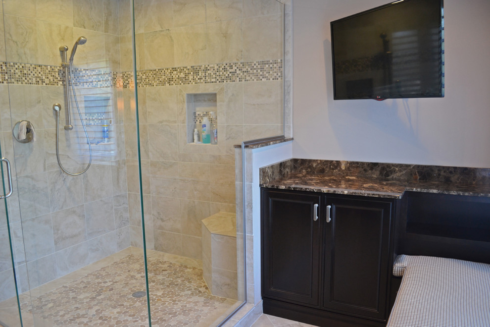 This is an example of a large transitional master bathroom in Dallas with an undermount sink, marble benchtops, a double shower, a two-piece toilet, beige tile, stone tile, beige walls, porcelain floors, raised-panel cabinets and dark wood cabinets.
