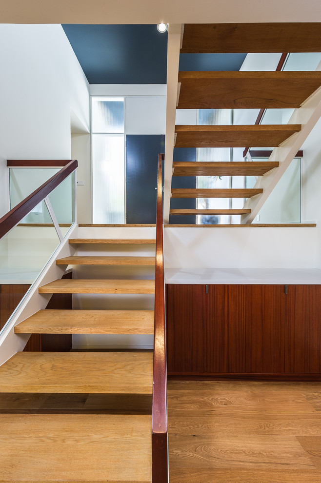 This is an example of a large midcentury wood u-shaped staircase in Los Angeles with open risers.