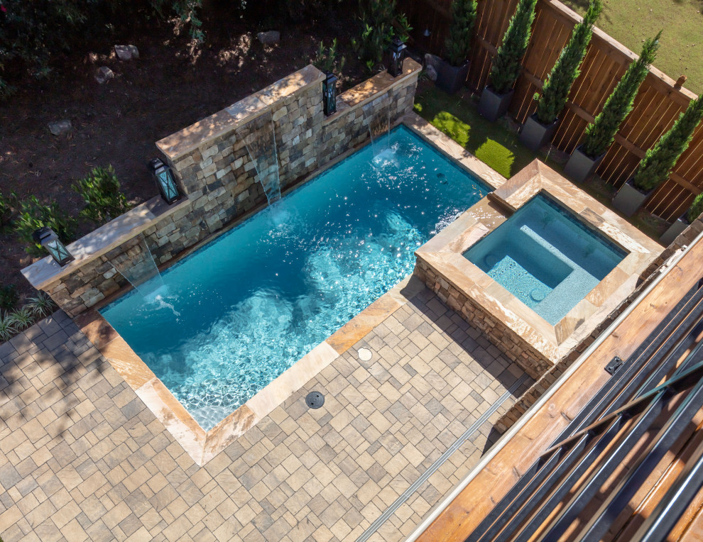 Mid-sized contemporary backyard rectangular natural pool in Atlanta with a hot tub and natural stone pavers.