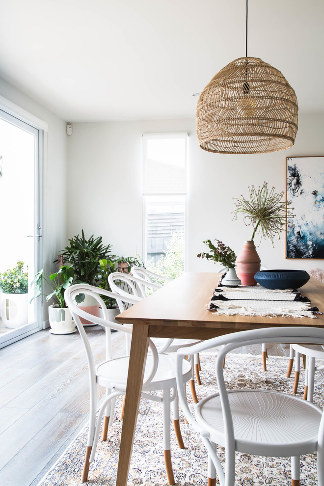 This is an example of a scandinavian open plan dining in Melbourne with white walls, dark hardwood floors and brown floor.