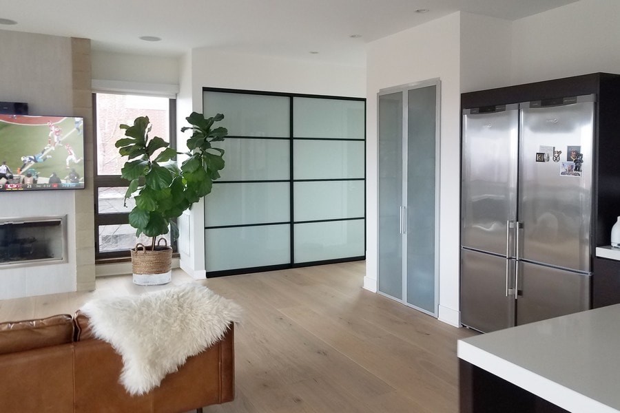 This is an example of a mid-sized contemporary built-in wardrobe in Chicago with open cabinets, white cabinets, light hardwood floors and beige floor.