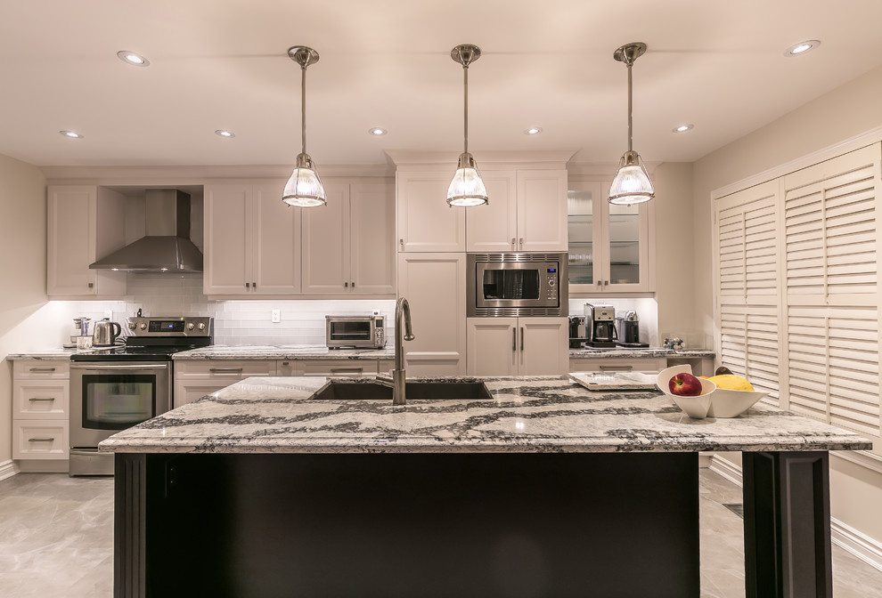 Large transitional gray floor enclosed kitchen photo in Toronto with an undermount sink, recessed-panel cabinets, white cabinets, quartz countertops, white backsplash, ceramic backsplash, stainless steel appliances and an island