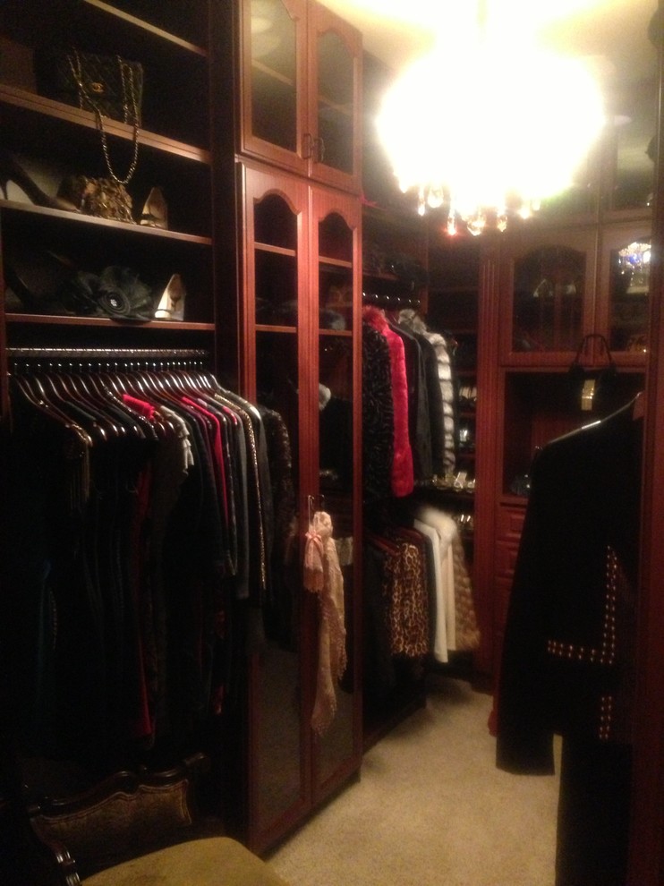 Imagen de armario vestidor unisex tradicional de tamaño medio con armarios con paneles con relieve, moqueta, puertas de armario marrones y suelo beige