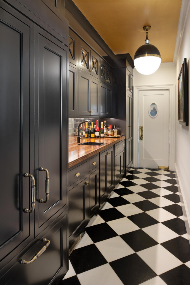Photo of a large traditional single-wall kitchen pantry in DC Metro with a drop-in sink, recessed-panel cabinets, black cabinets, wood benchtops, metallic splashback, metal splashback, panelled appliances, ceramic floors, with island, multi-coloured floor and brown benchtop.