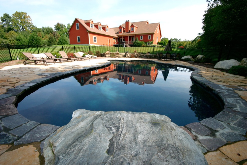 Large mountain style backyard stone and custom-shaped natural pool photo in New York