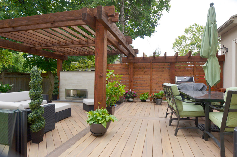 Mid-sized modern backyard deck in Toronto with a fire feature and a pergola.