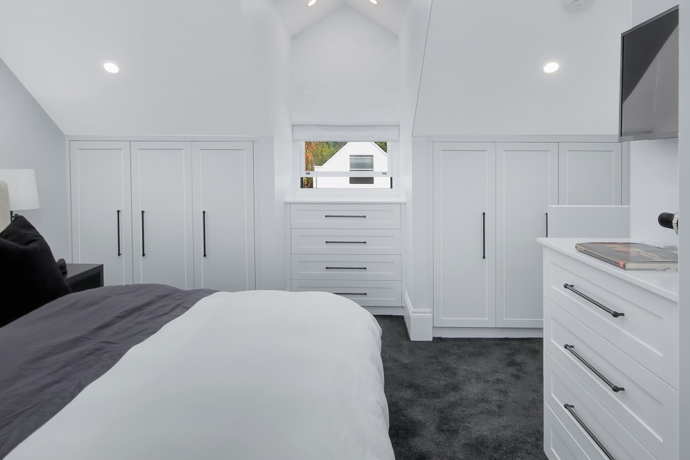 Esempio di un piccolo armadio incassato unisex minimalista con ante in stile shaker, ante bianche, moquette e pavimento nero