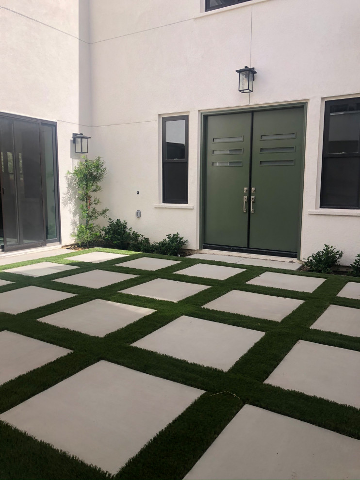 Modern courtyard full sun formal garden in San Diego with with path and concrete pavers for spring.