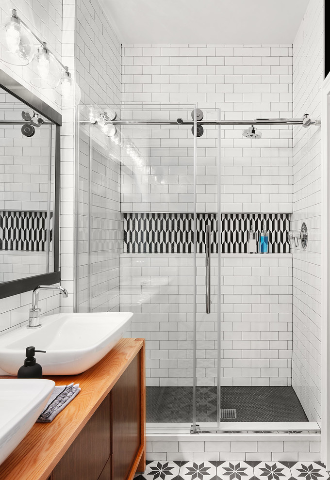 Design ideas for a mid-sized contemporary bathroom in Chicago with flat-panel cabinets, medium wood cabinets, a corner shower, black and white tile, white tile, subway tile, white walls, a vessel sink, wood benchtops, multi-coloured floor, a sliding shower screen and brown benchtops.