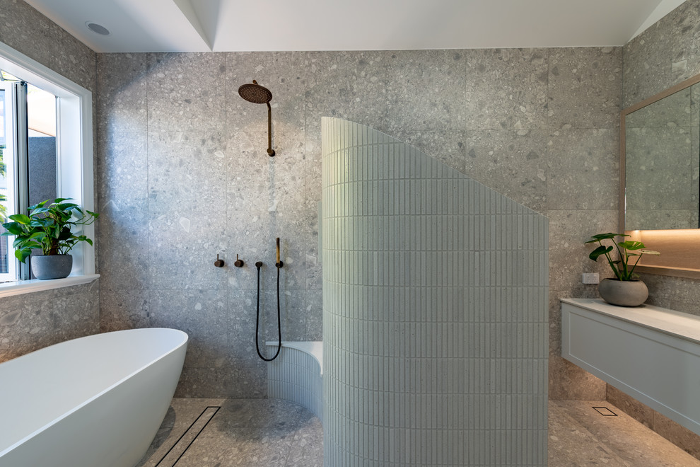 Photo of a large contemporary master wet room bathroom in Perth with shaker cabinets, white cabinets, a freestanding tub, a two-piece toilet, gray tile, porcelain tile, grey walls, porcelain floors, a vessel sink, engineered quartz benchtops, grey floor, an open shower and white benchtops.