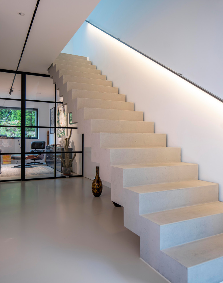 This is an example of a contemporary concrete straight metal railing staircase in Munich with concrete risers.