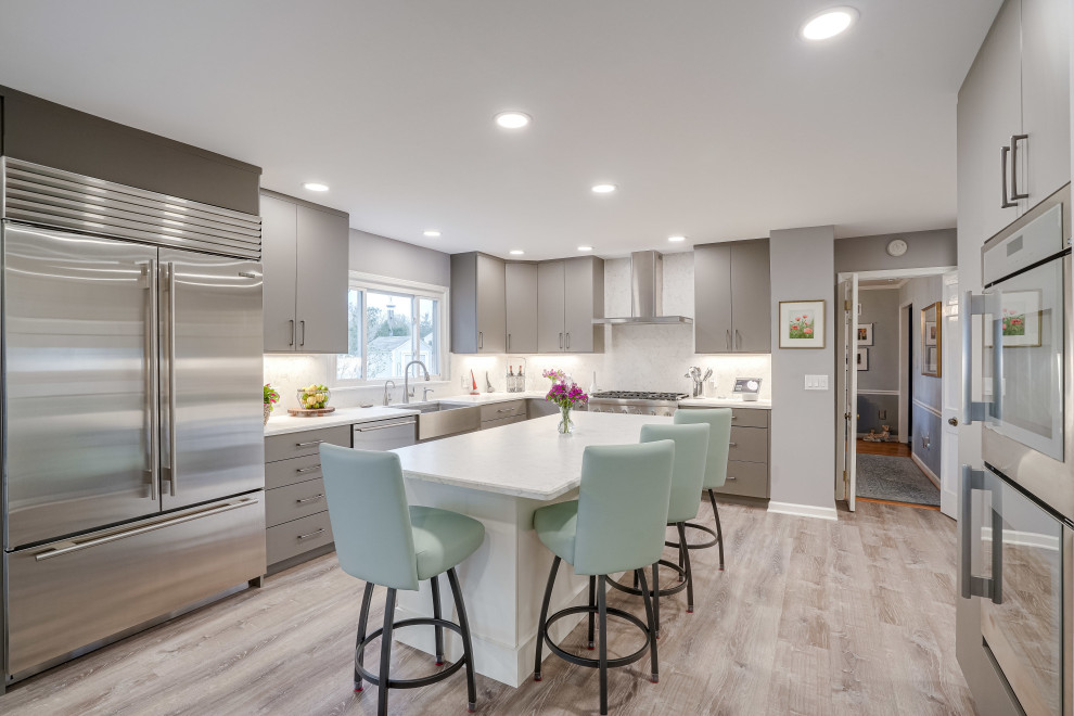 Inspiration for an expansive contemporary u-shaped eat-in kitchen in DC Metro with a farmhouse sink, flat-panel cabinets, brown cabinets, quartz benchtops, engineered quartz splashback, stainless steel appliances and with island.