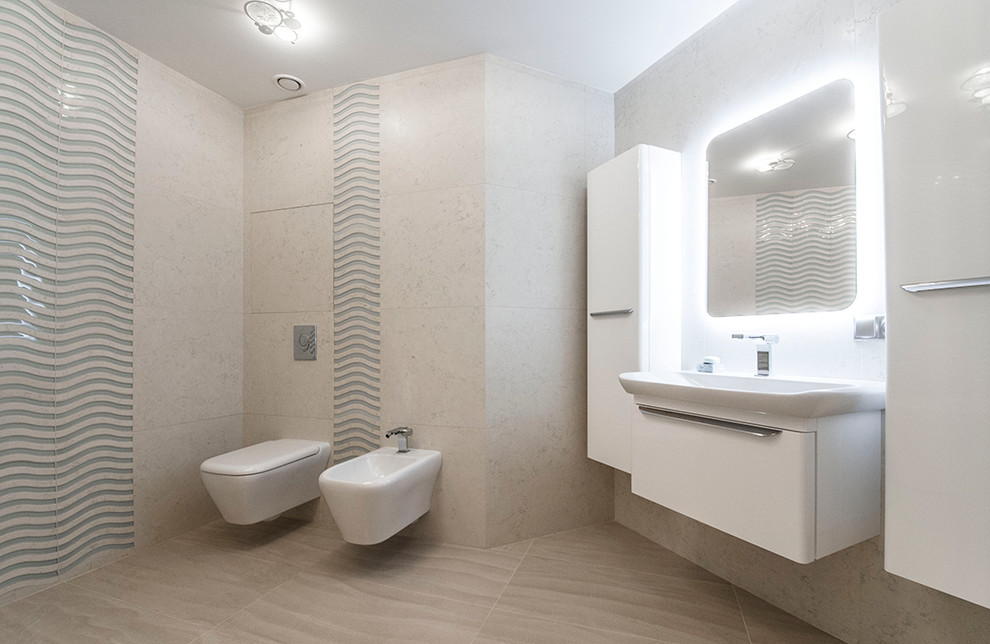 Пример оригинального дизайна: большая главная ванная комната в современном стиле с белыми фасадами, угловой ванной, биде, бежевой плиткой, мраморной плиткой, бежевыми стенами, полом из керамогранита и настольной раковиной