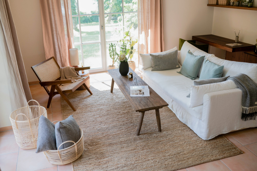 Ejemplo de sala de estar abierta mediterránea de tamaño medio con paredes beige, suelo de baldosas de terracota, estufa de leña y suelo naranja