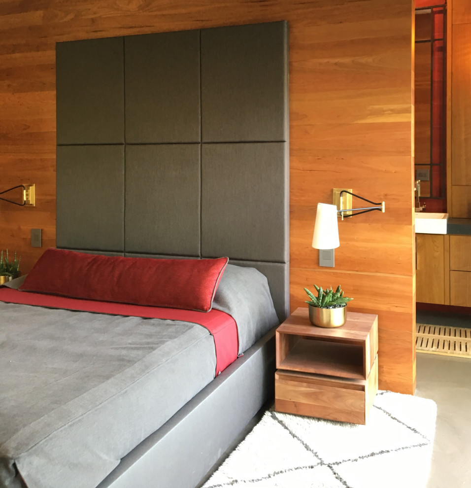 バンクーバーにあるミッドセンチュリースタイルのおしゃれな客用寝室 (緑の壁、コンクリートの床、標準型暖炉、石材の暖炉まわり、グレーの床、塗装板張りの壁)