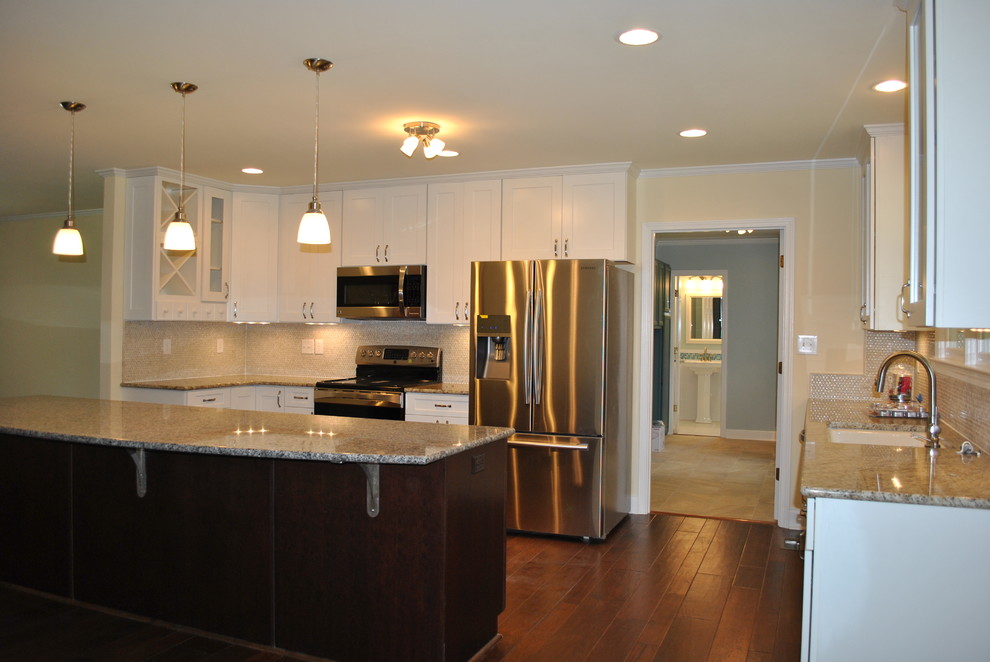 Large transitional single-wall dark wood floor and brown floor eat-in kitchen photo with an undermount sink, shaker cabinets, white cabinets, granite countertops, beige backsplash, stainless steel appliances and an island
