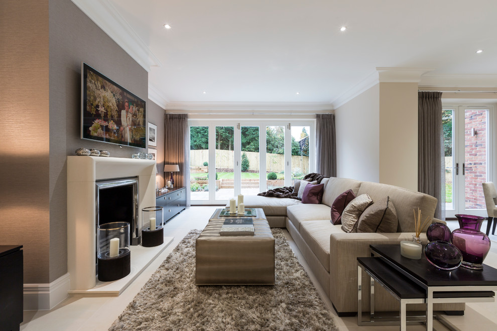 This is an example of a transitional open concept living room in Surrey with grey walls, a standard fireplace, a metal fireplace surround and a wall-mounted tv.